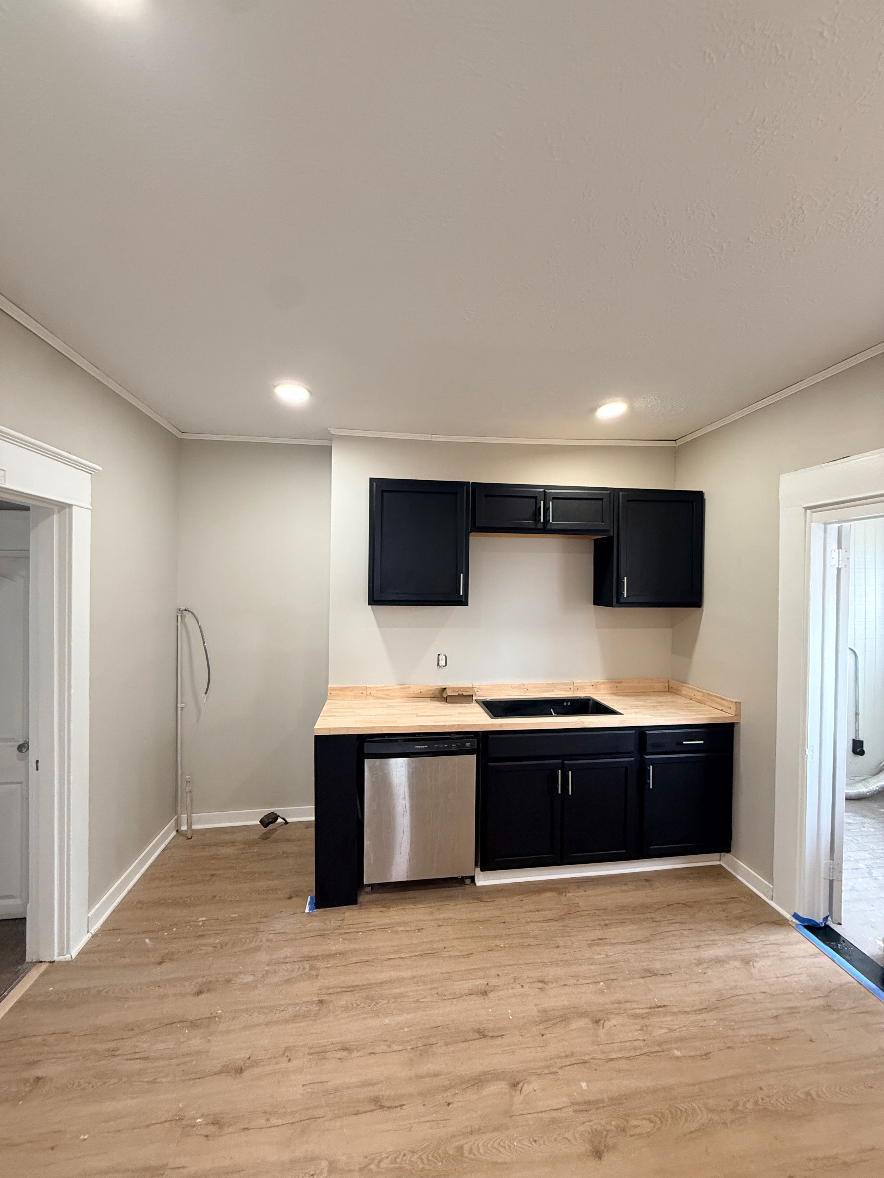 Kitchen renovation in progress with dark cabinets and wood countertops
