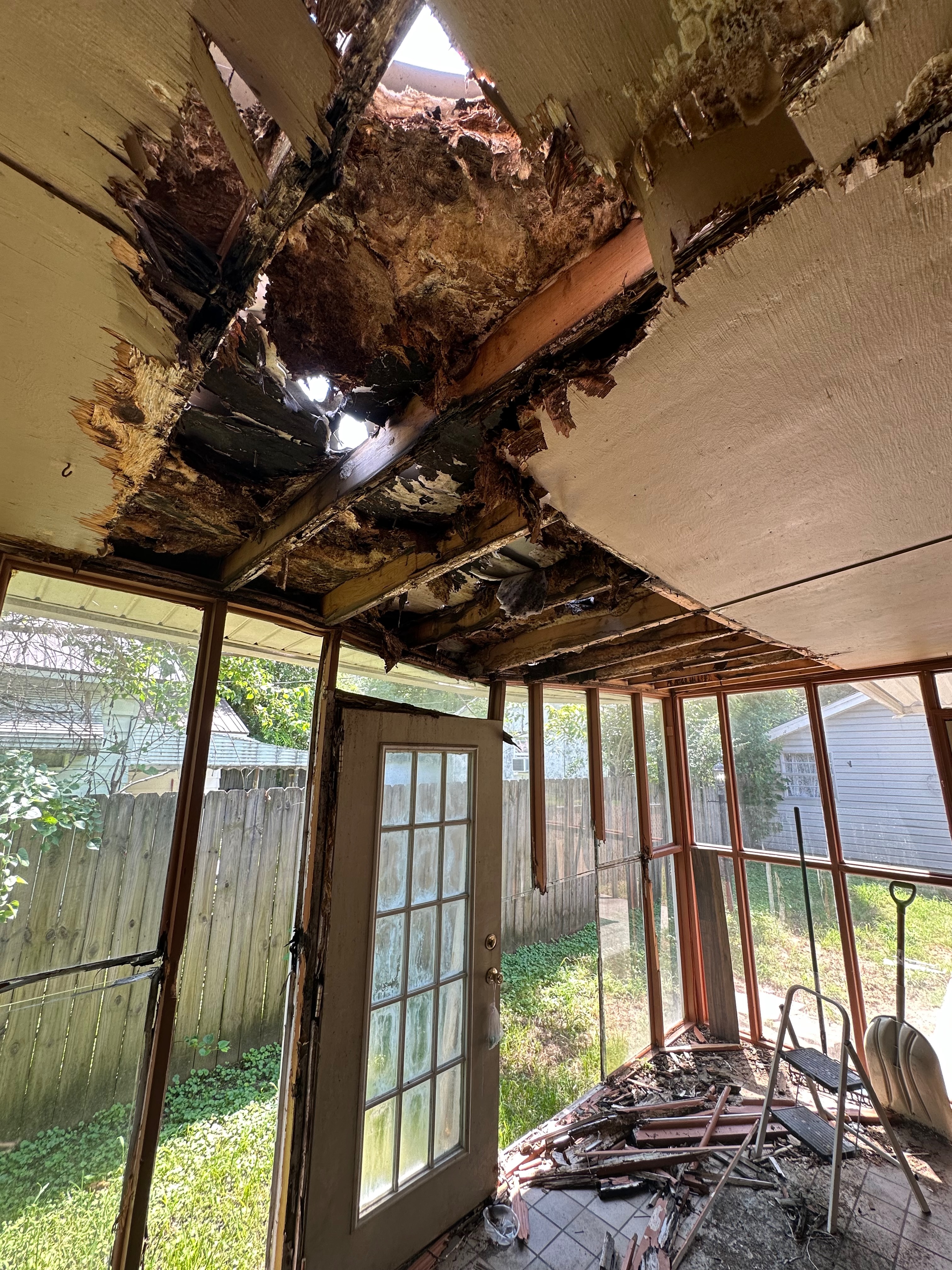 An older porch with damaged roofing and flooring before repairs